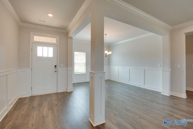 entrance foyer featuring crown molding, dark wood-type flooring, and an inviting chandelier