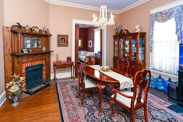 dining space with a chandelier, crown molding, a wealth of natural light, and wood finished floors