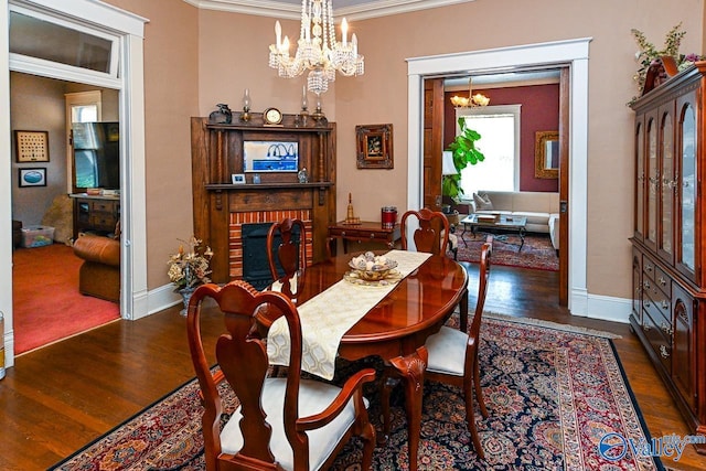 dining space with a notable chandelier, ornamental molding, baseboards, and wood finished floors