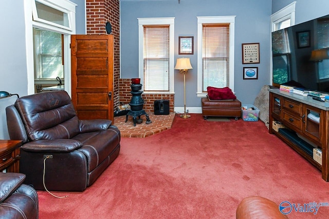 carpeted living area with a wealth of natural light, brick wall, and a wood stove