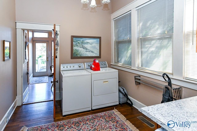 laundry area featuring washing machine and clothes dryer, visible vents, dark wood finished floors, laundry area, and a notable chandelier