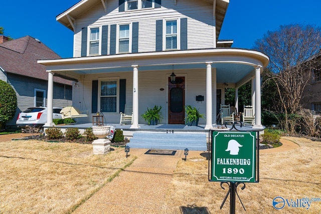 view of front facade with covered porch and a front yard