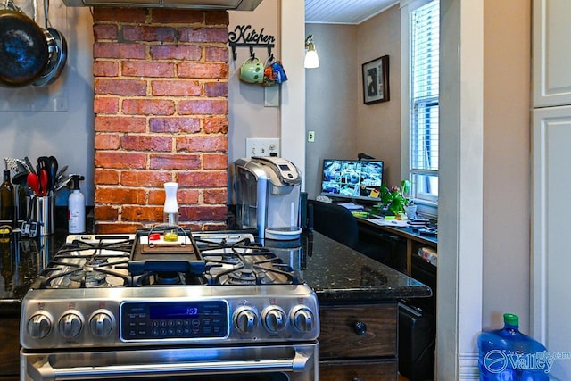 kitchen featuring dark stone counters and gas stove