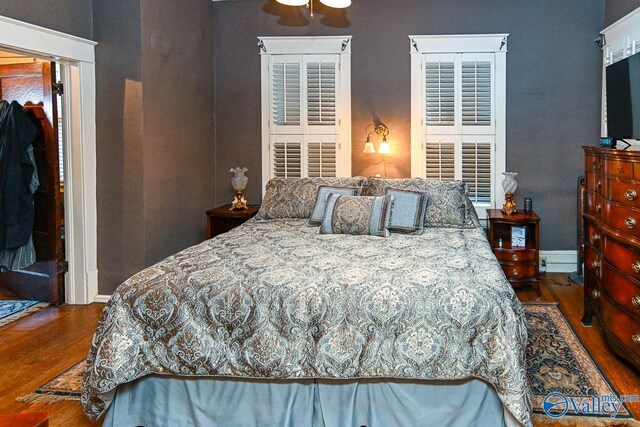 bedroom with baseboards and wood finished floors