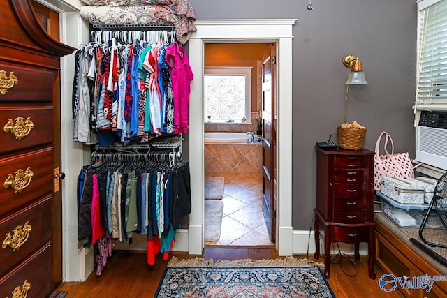 walk in closet with wood finished floors