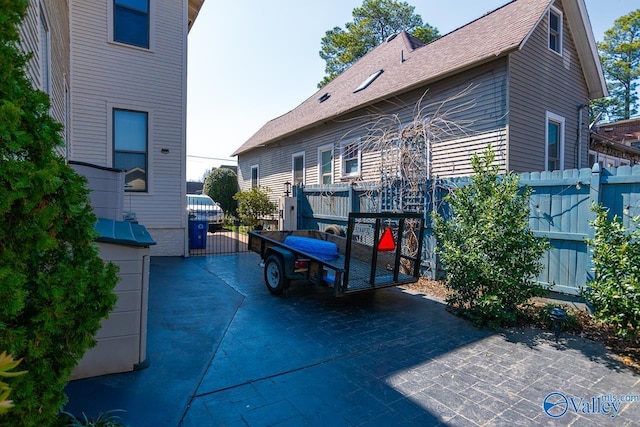 exterior space featuring roof with shingles and fence