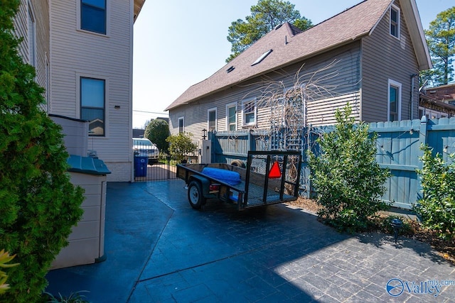 exterior space featuring a shingled roof and fence