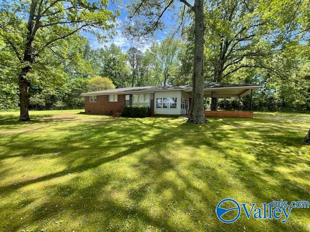 view of front of property featuring a front lawn and a carport