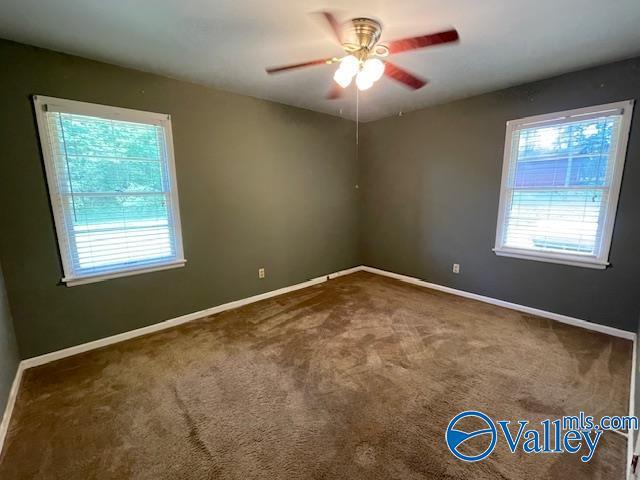 carpeted spare room with baseboards and ceiling fan