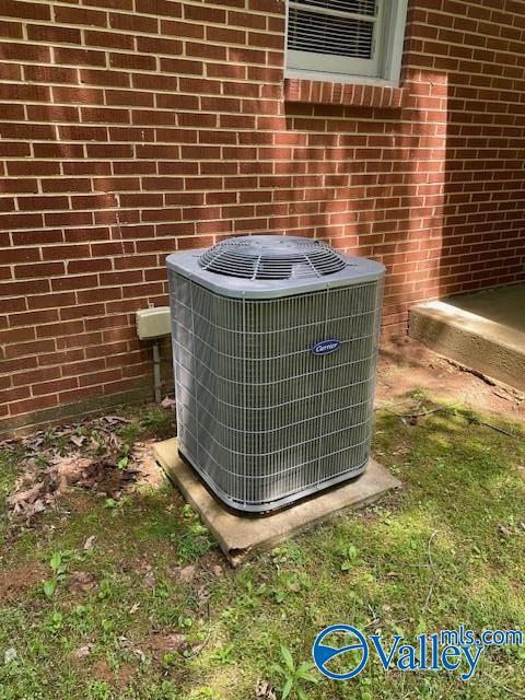 exterior details featuring brick siding and central AC unit
