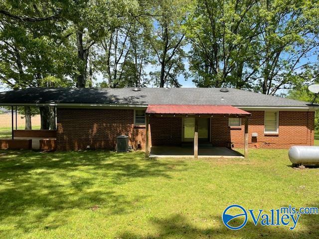 back of house with a patio, a yard, central AC, and brick siding