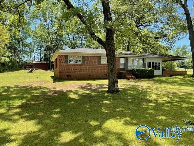 view of front of property featuring a front lawn, crawl space, entry steps, and brick siding