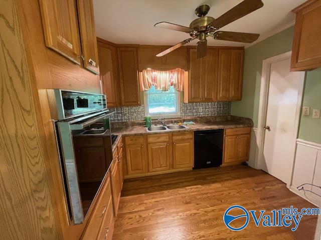 kitchen featuring a sink, decorative backsplash, oven, a ceiling fan, and dishwasher