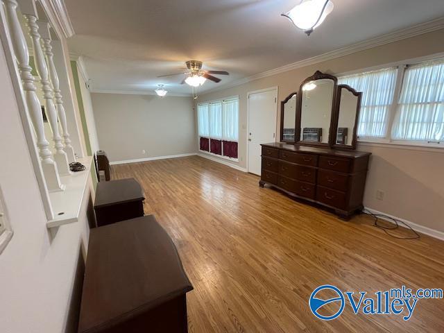 bedroom featuring wood finished floors, ornamental molding, and baseboards