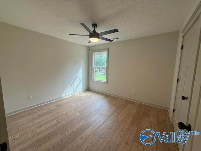 6255 Vista Trl, Southside, AL 35907 - unfurnished bedroom with wood-type flooring, baseboards, a textured ceiling, and ceiling fan
