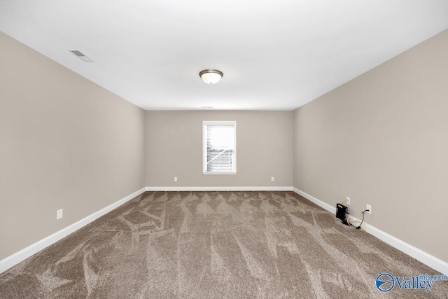 carpeted spare room with visible vents and baseboards
