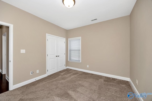 unfurnished bedroom featuring a closet, baseboards, visible vents, and carpet floors