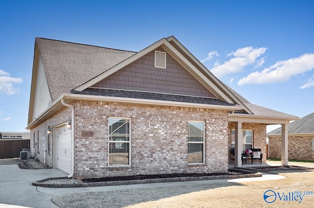 view of front of house with a garage, brick siding, concrete driveway, and a shingled roof