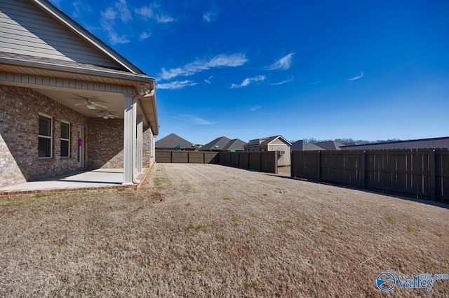 view of yard featuring a patio area, a ceiling fan, and a fenced backyard