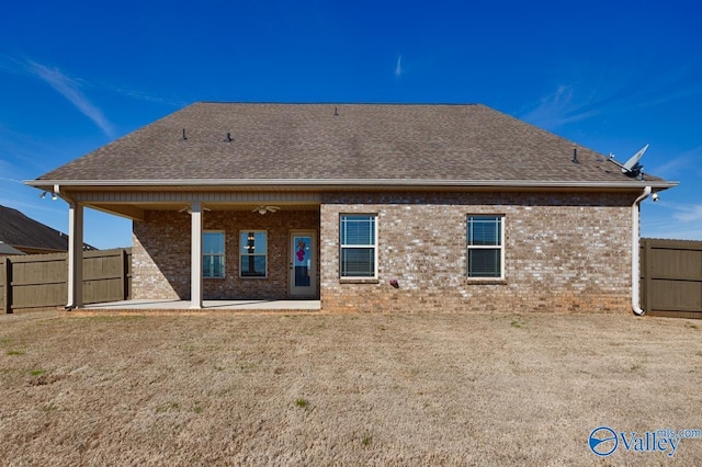 rear view of property with a patio, fence, brick siding, and a shingled roof