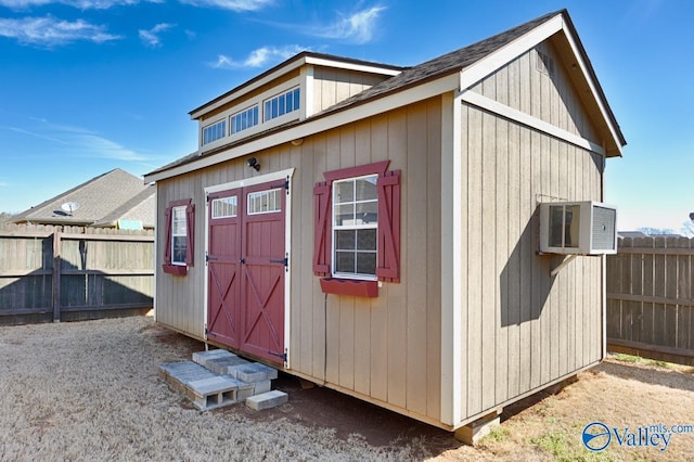 view of shed featuring a wall mounted air conditioner and a fenced backyard