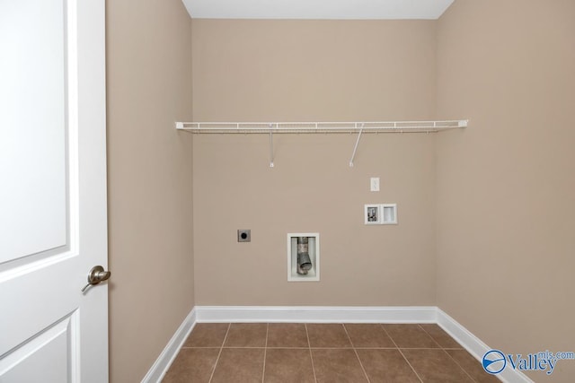 washroom featuring baseboards, hookup for an electric dryer, laundry area, dark tile patterned flooring, and washer hookup