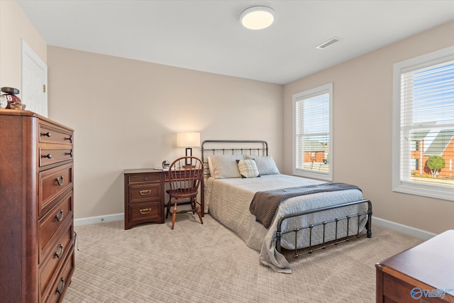 bedroom featuring light carpet, visible vents, and baseboards