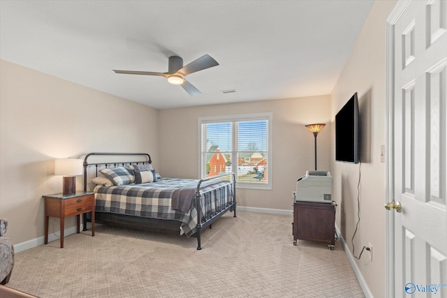 bedroom featuring baseboards, a ceiling fan, visible vents, and light colored carpet