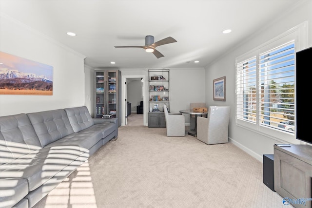 living area featuring light carpet, baseboards, a ceiling fan, ornamental molding, and recessed lighting