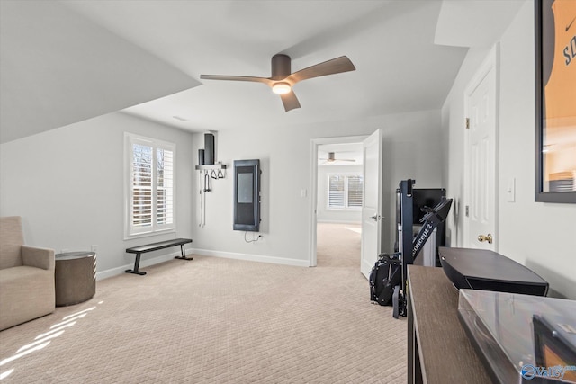 exercise room with light carpet, ceiling fan, and baseboards