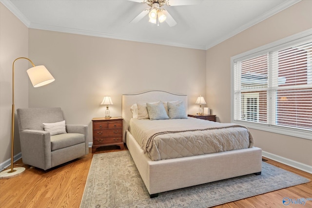 bedroom with light wood-style floors, ornamental molding, baseboards, and a ceiling fan