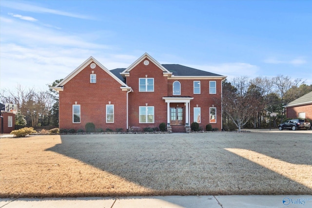 view of front of home featuring a front yard and brick siding