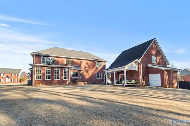 back of property with a lawn and brick siding