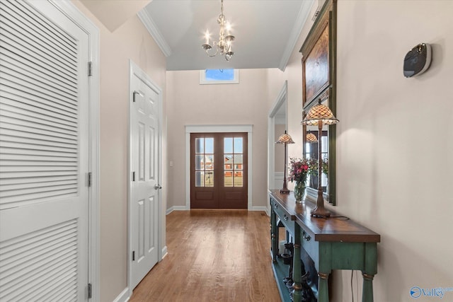 entryway featuring a notable chandelier, a wealth of natural light, crown molding, and wood finished floors