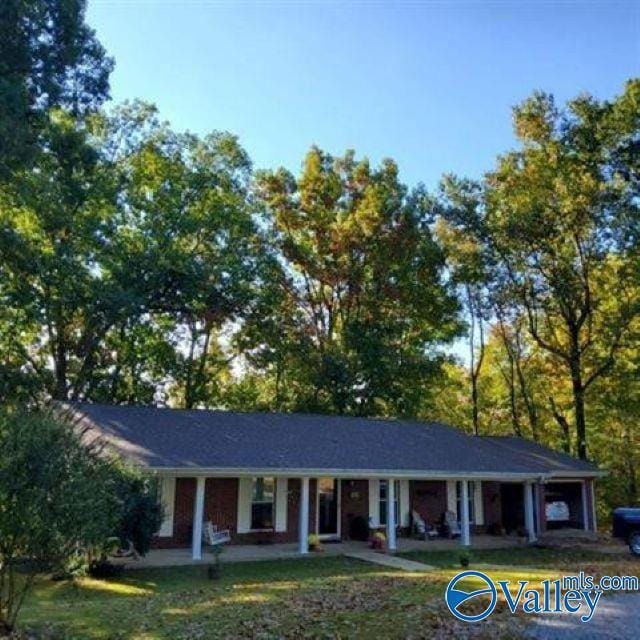 ranch-style home with a porch and a front yard