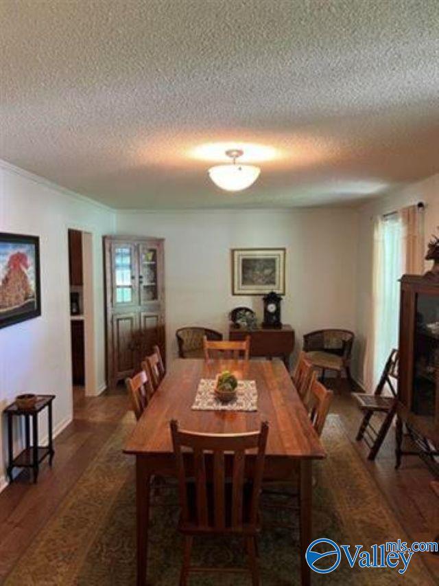 dining space featuring plenty of natural light, a textured ceiling, and wood finished floors