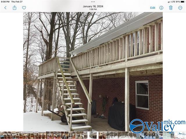 view of side of property with stairs and brick siding