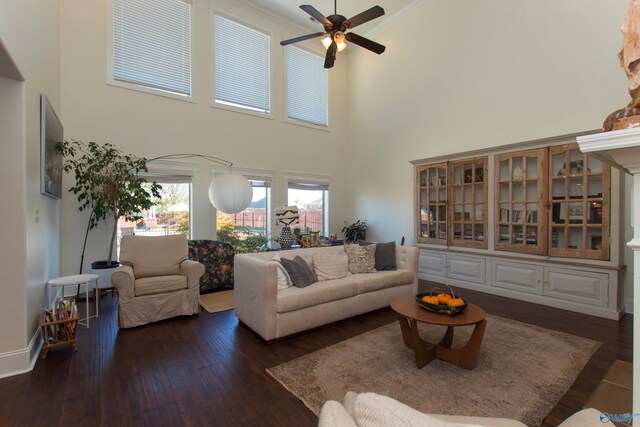 living room featuring dark hardwood / wood-style floors, a high ceiling, and ceiling fan