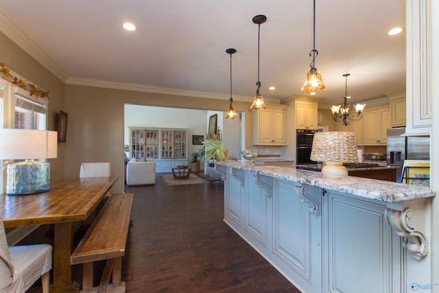 kitchen with ornamental molding, dark hardwood / wood-style floors, black double oven, light stone countertops, and hanging light fixtures