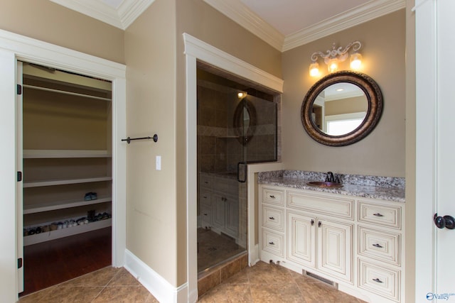 bathroom featuring ornamental molding, a tile shower, vanity, and tile patterned floors