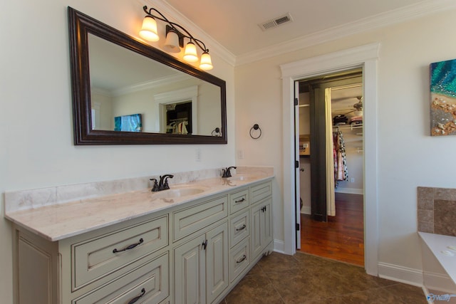 bathroom featuring vanity, a tub to relax in, tile patterned flooring, and crown molding