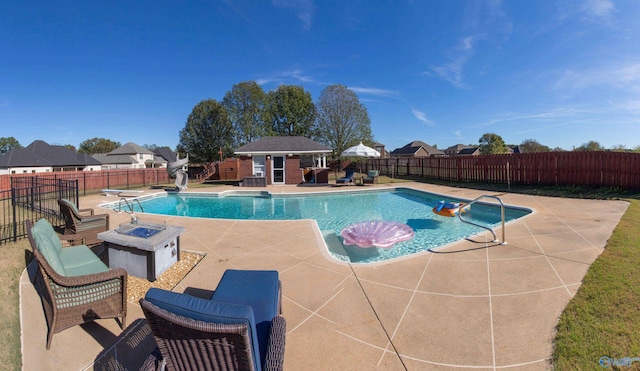 view of swimming pool featuring an outbuilding, a patio, a fire pit, and a diving board