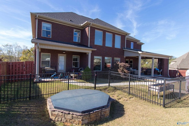 rear view of house with a yard and a patio