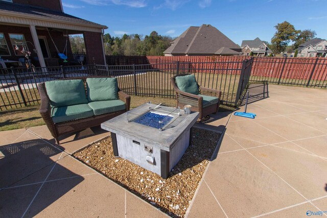 view of patio with an outdoor living space with a fire pit