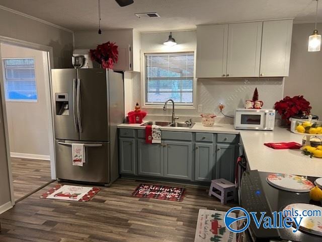 kitchen with stainless steel refrigerator with ice dispenser, crown molding, dark wood-type flooring, sink, and decorative light fixtures