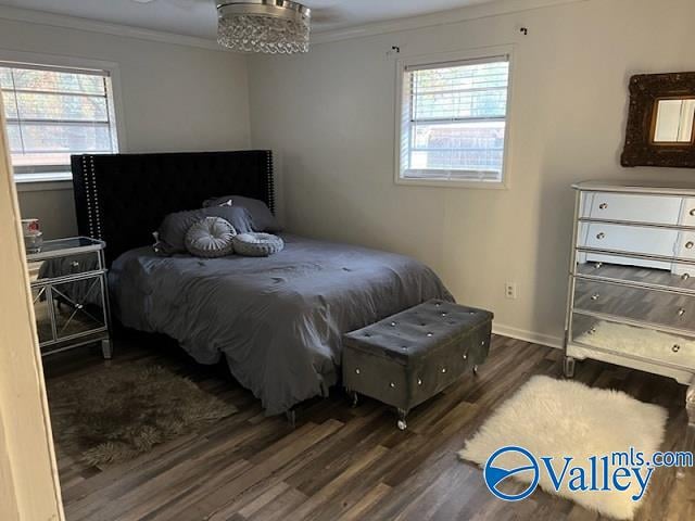 bedroom with ornamental molding, dark wood-type flooring, and multiple windows