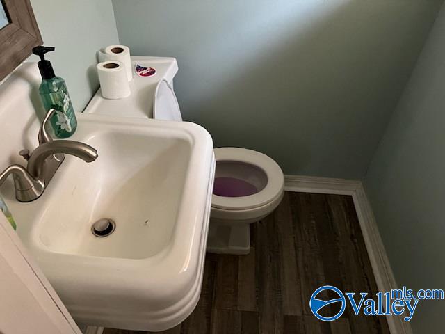 bathroom featuring sink, wood-type flooring, and toilet