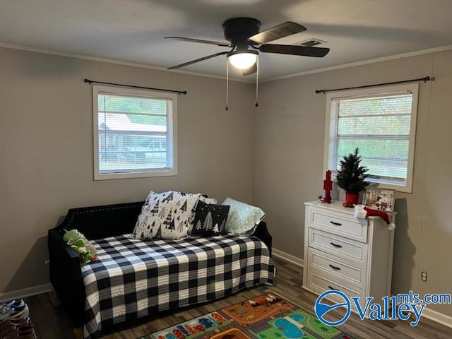 bedroom with crown molding, multiple windows, dark wood-type flooring, and ceiling fan