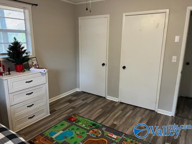 bedroom featuring crown molding and dark wood-type flooring