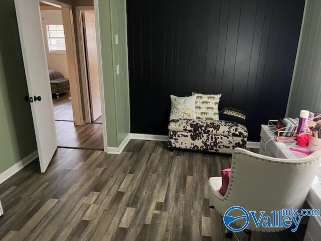 sitting room with wood walls and dark hardwood / wood-style floors